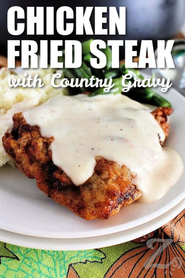 chicken fried steak with country gravy on a white plate with mashed potatoes and green beans on the side, with a title