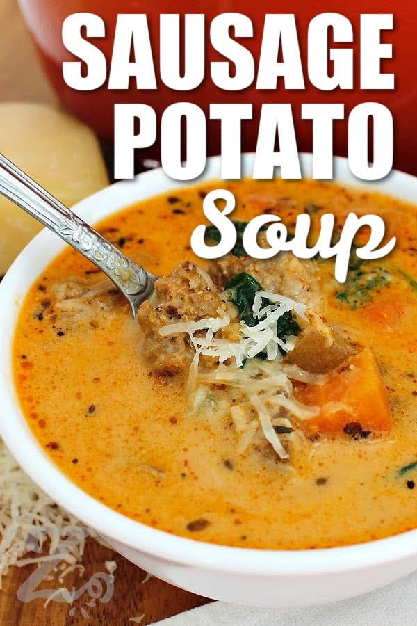 Creamy, hearty, and packed with savory flavor, this Sausage Potato Soup is an easy comfort food dinner that is also easy to make in one pot. Italian sausage, tender potatoes, vegetables, and spinach simmer together in a rich broth with a touch of cream. This soup is perfect for fall and winter nights so why not give this cozy soup a try tonight? #ourzestylife sausage potato soup in a white bowl with shredded parmesan garnish and a spoon, with a title.