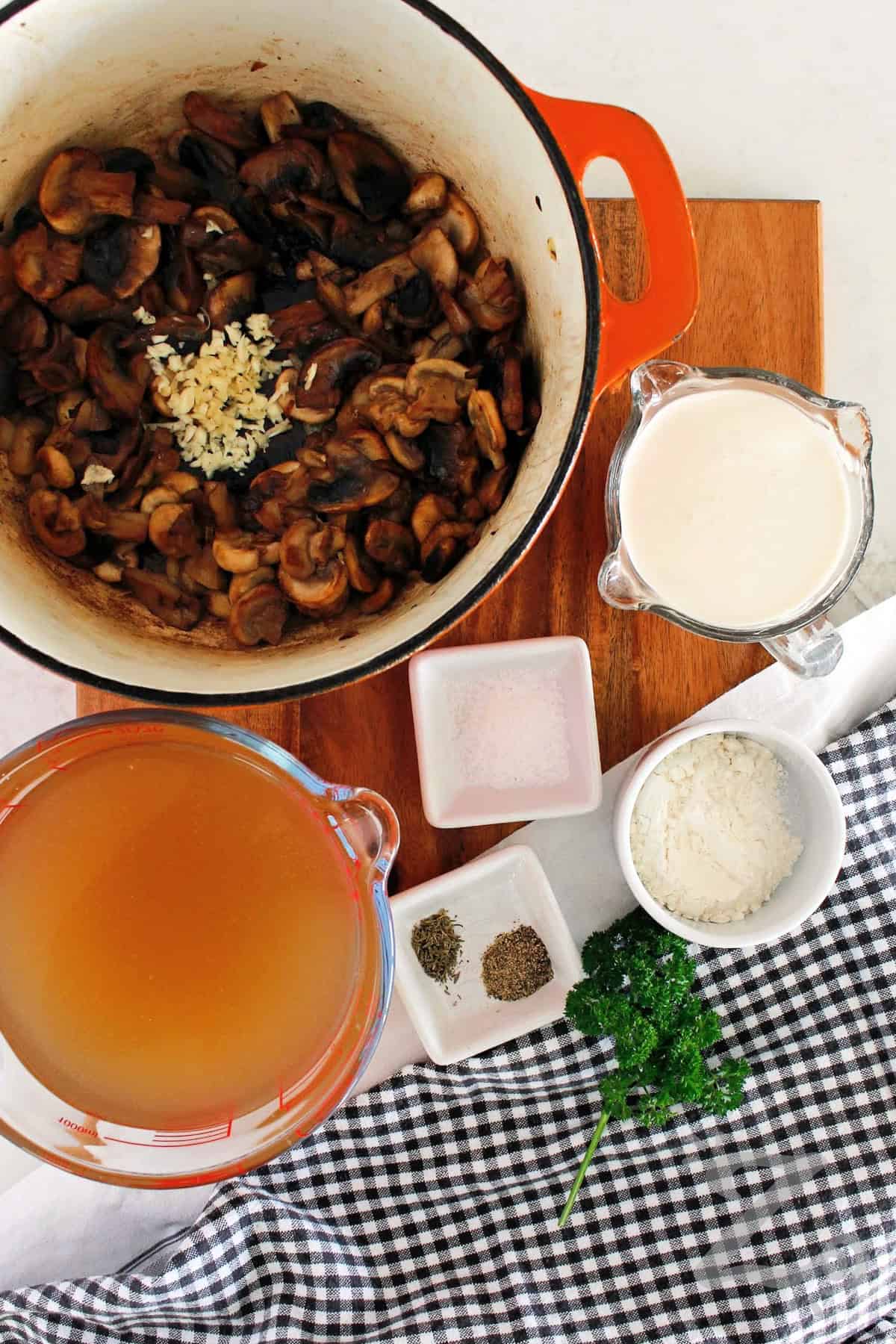 Minced garlic added to sauteed mushrooms to make homemade cream of mushroom soup.